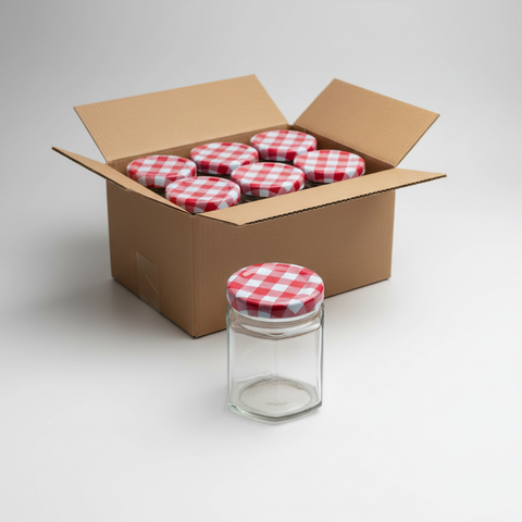 Frasco hexagonal de vidrio 180ml con tapa de cuadros delante de caja de cartón con pack de 24 unidades